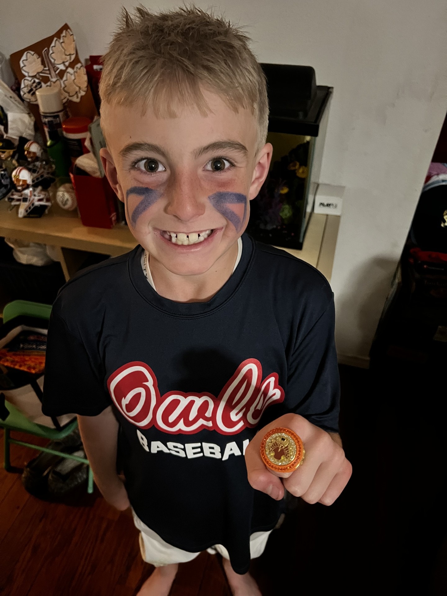 Ryan wearing baseball gear and showing a championship ring
